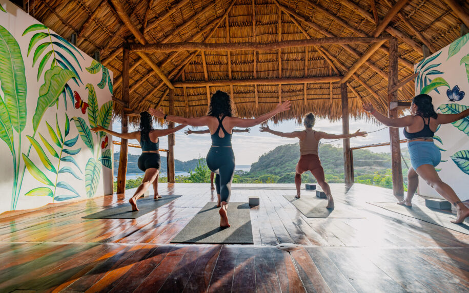 woman doing yoga on ocean view yoga deck